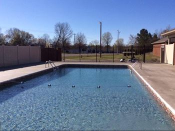 A large outdoor swimming pool with people in it.